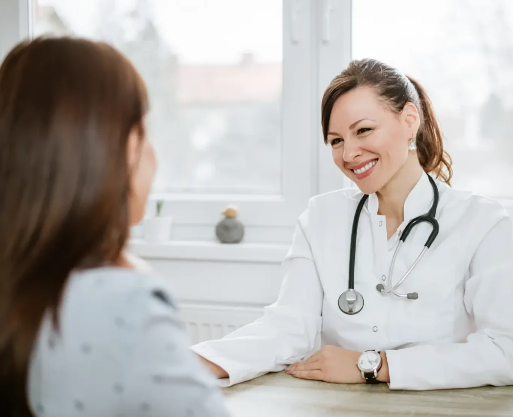 A woman engages in conversation with a doctor, seeking medical advice in a clinical environment.