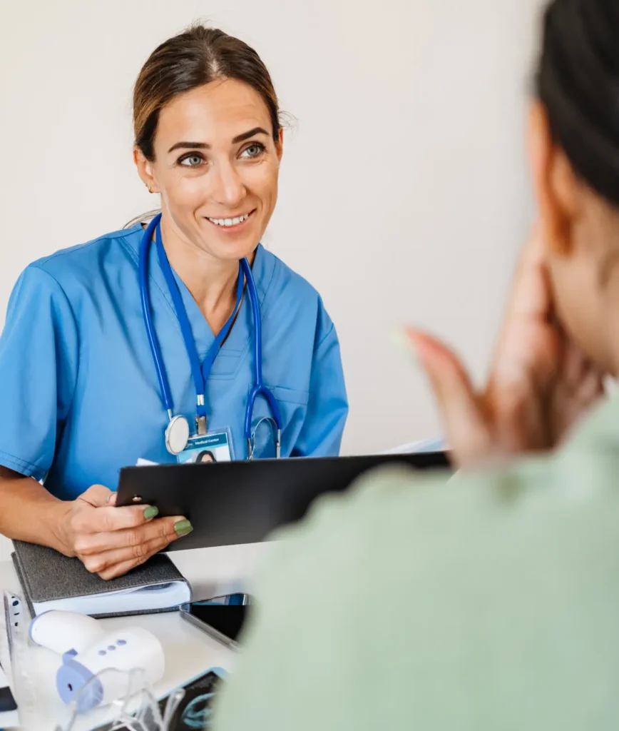 A female nurse engages in conversation with a patient in a healthcare setting, providing support and care.